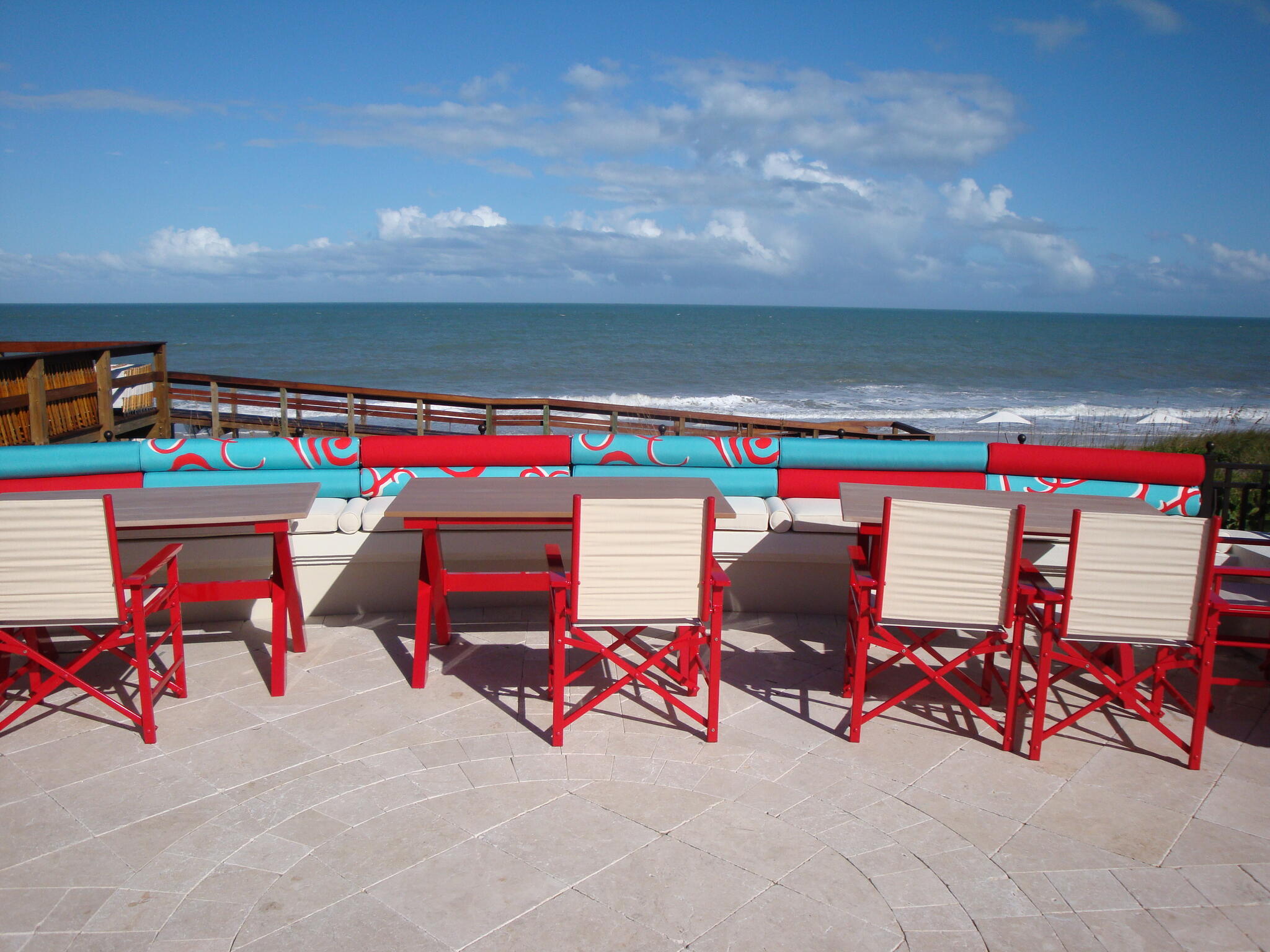 Outdoor seating arrangement with turquoise and red cushions